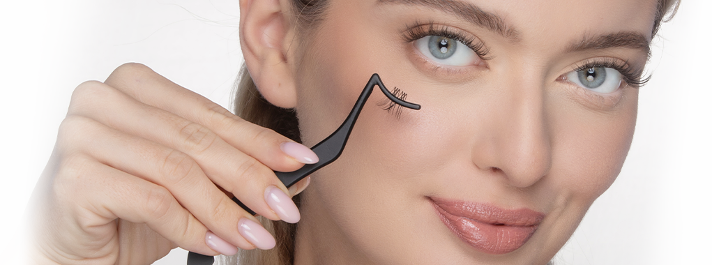 Kobieta przykłada aplikator do rzęs do twarzy